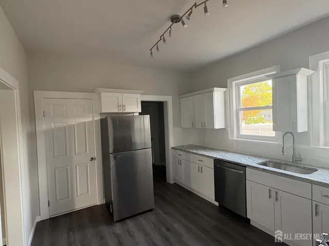 a kitchen with a refrigerator sink and cabinets