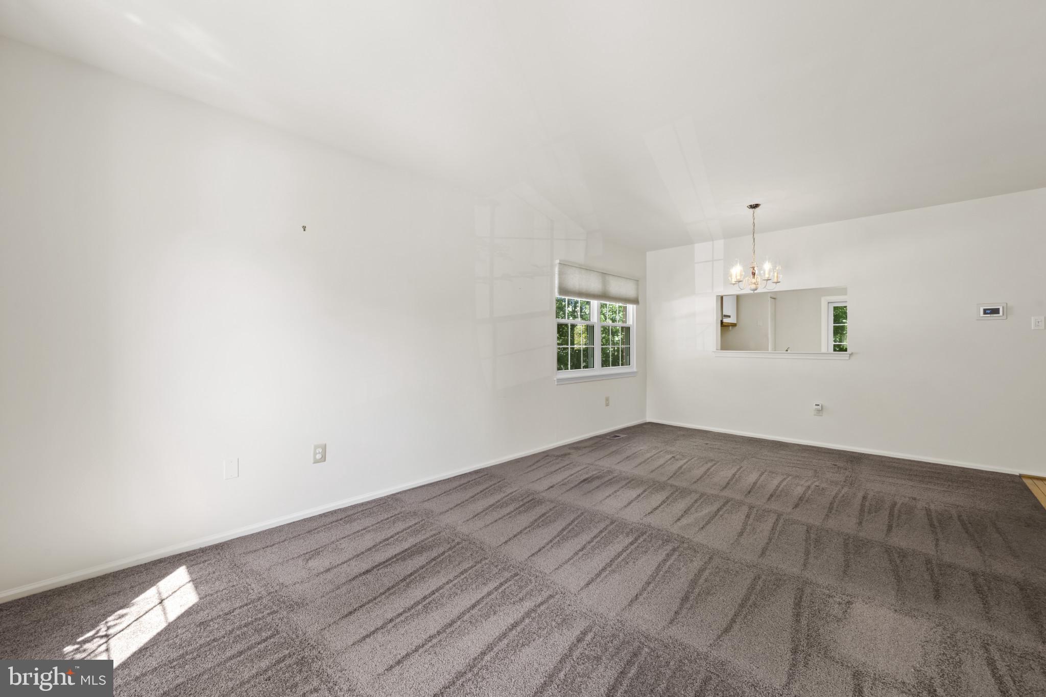 4031 Forest Valley Road Baltimore, MD 21234 - Photo 7 of 30 an empty room with windows and chandelier fan