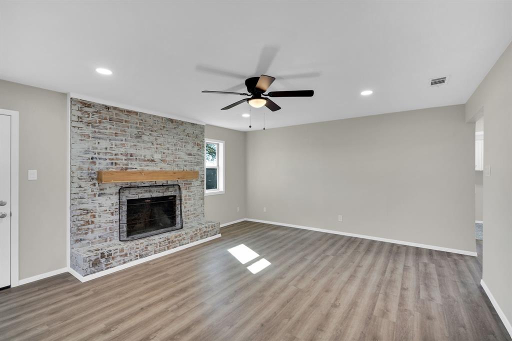 221 North Edgefield Road Waxahachie, TX 75165 - Photo 5 of 27 a view of empty room with wooden floor and fireplace