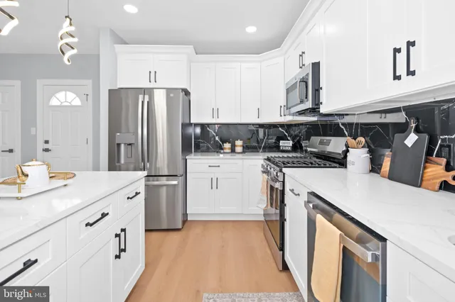a kitchen with a sink a stove a refrigerator and cabinets