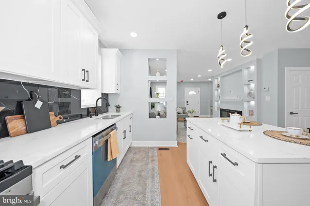 a large kitchen with kitchen island a sink stove and white cabinets