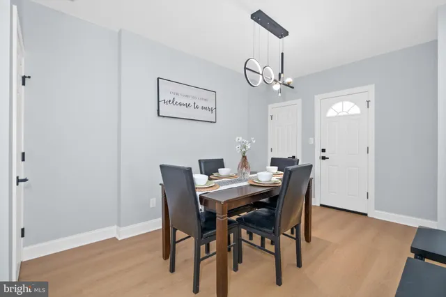 a view of a dining room with furniture a chandelier and wooden floor