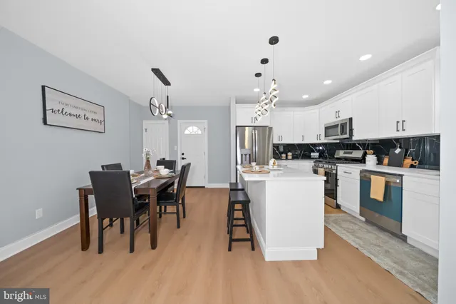 a kitchen with a dining table chairs and white appliances