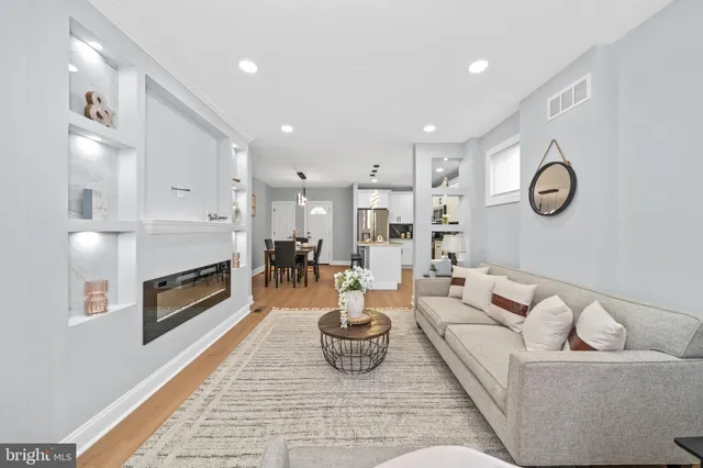 a living room with furniture kitchen view and a fireplace