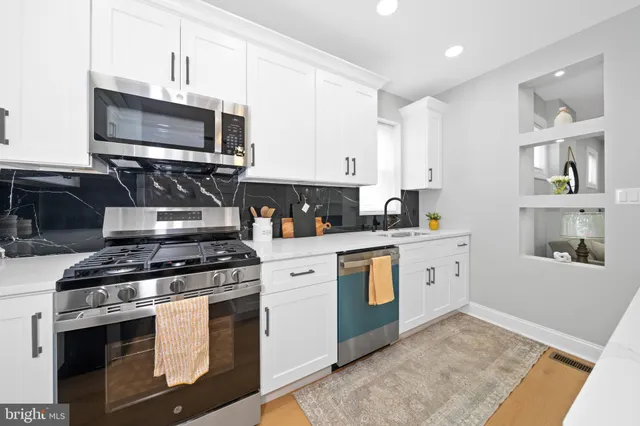 a kitchen with stainless steel appliances a stove a microwave and cabinets