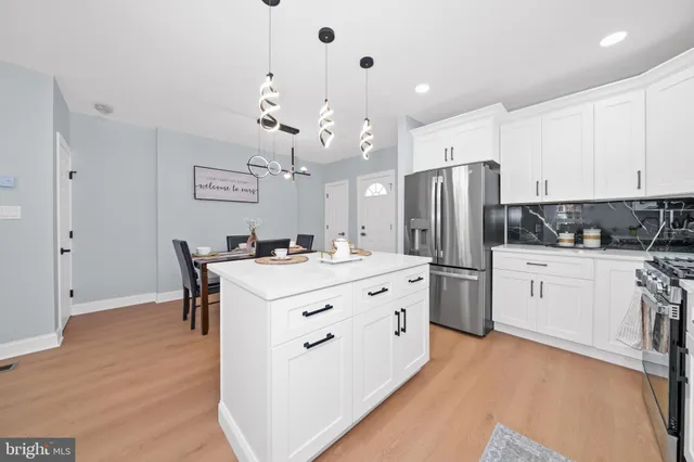 a kitchen with refrigerator a stove a sink dishwasher with a dining table and chairs