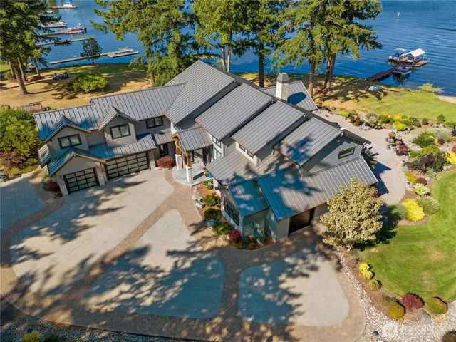 an aerial view of a house with a yard and lake view