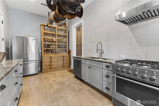 a kitchen with stainless steel appliances a stove a sink and a refrigerator