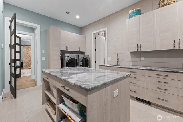 a kitchen with stainless steel appliances granite countertop a sink and dishwasher with white cabinets