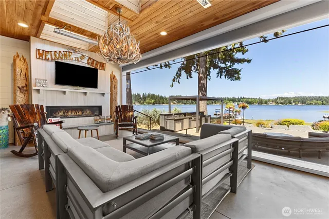 a living room with furniture a flat screen tv and a floor to ceiling window