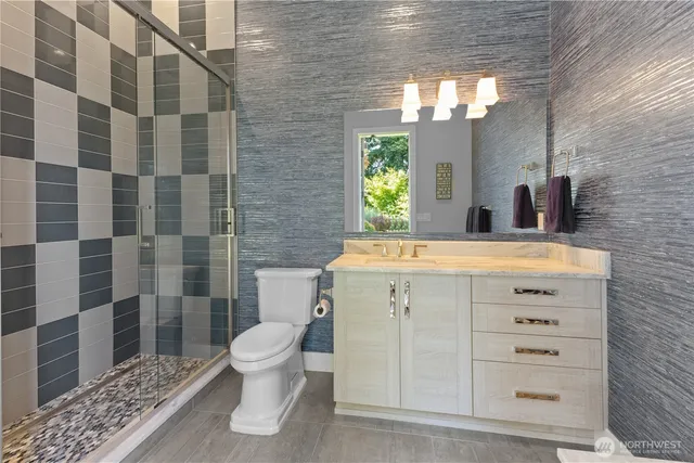 a bathroom with a sink a toilet and shower