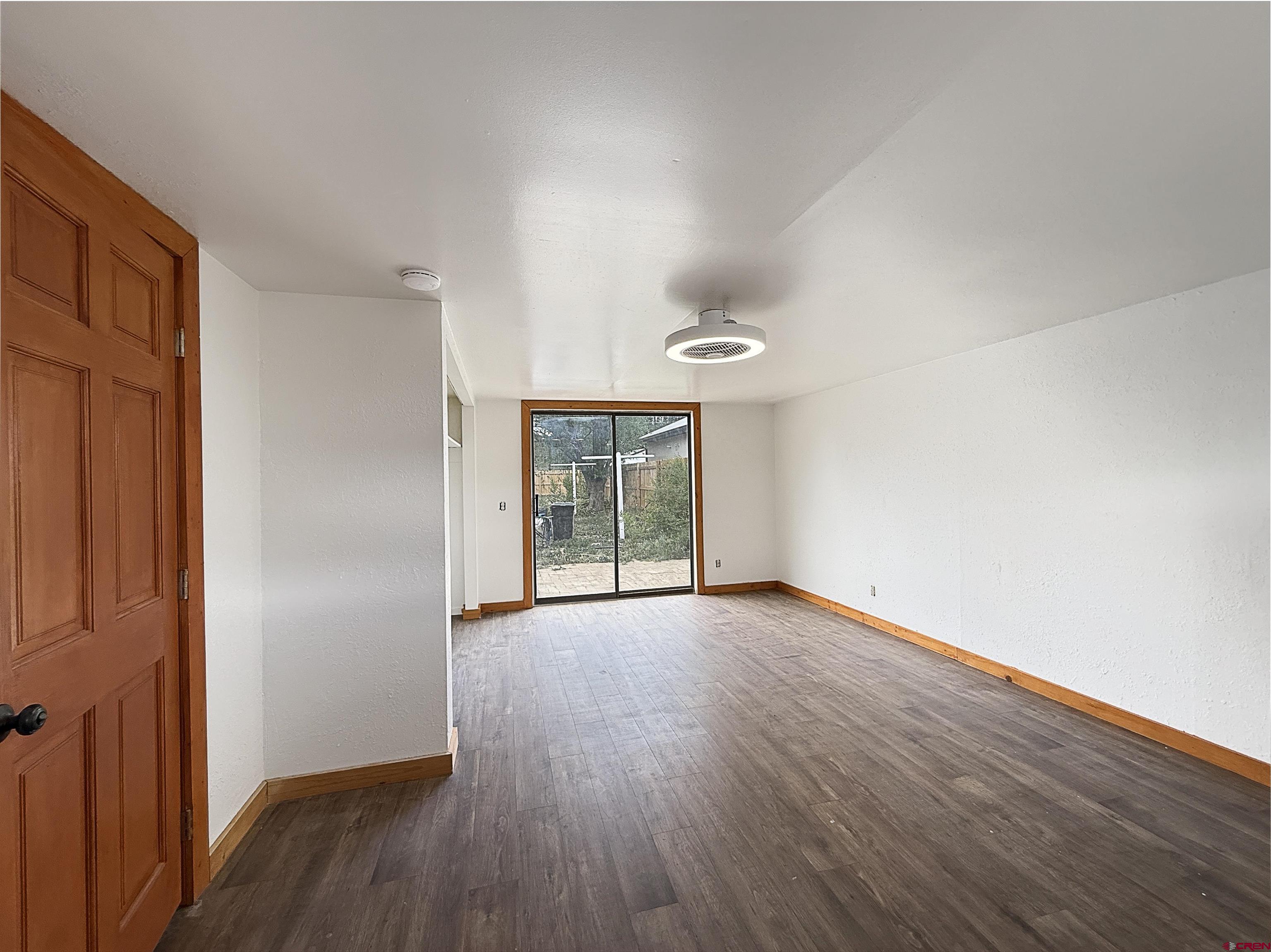 1246 Meeker Street Delta, CO 81416 - Photo 12 of 21 an empty room with wooden floor and windows
