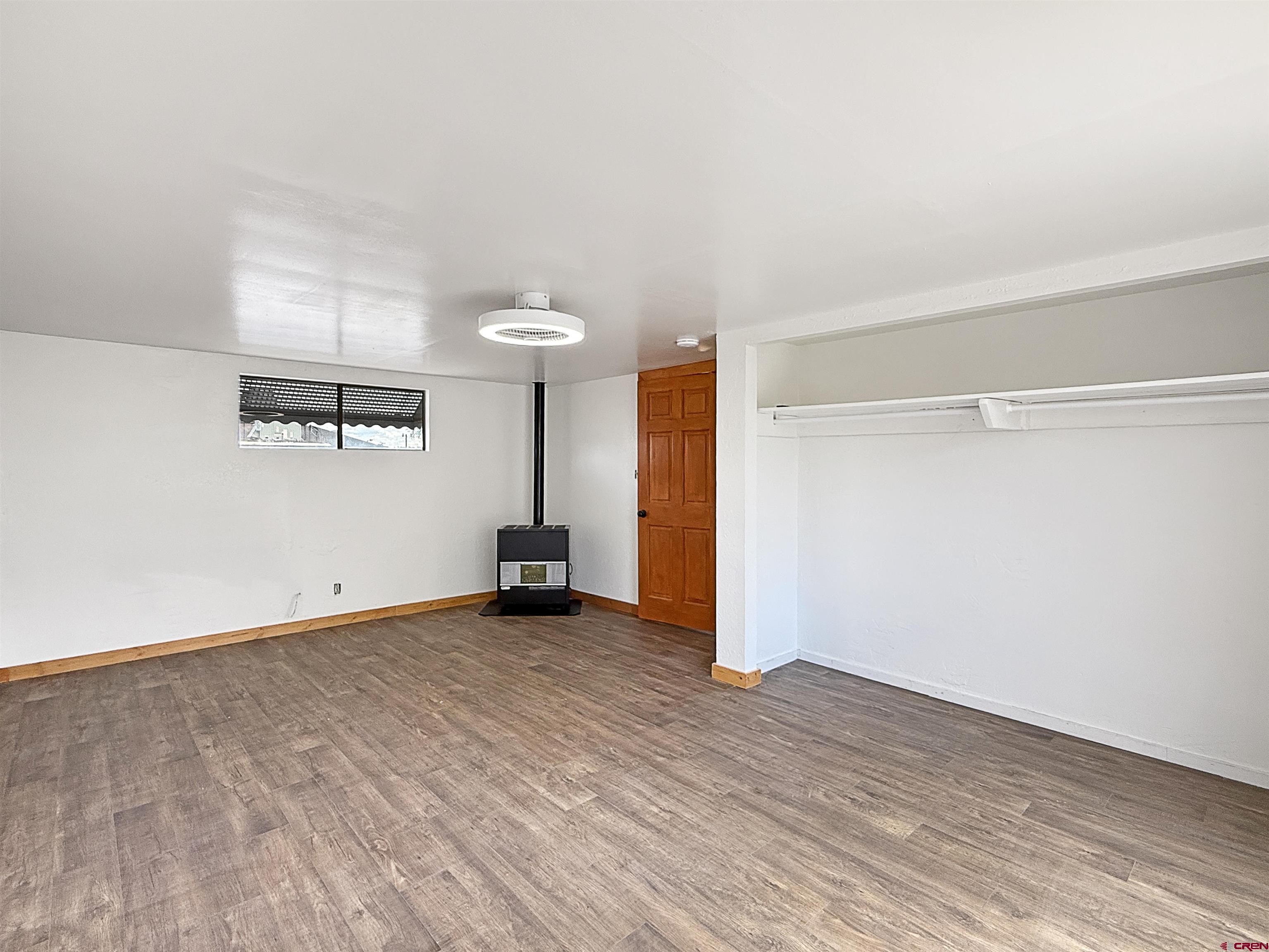 1246 Meeker Street Delta, CO 81416 - Photo 14 of 21 an empty room with wooden floor and windows