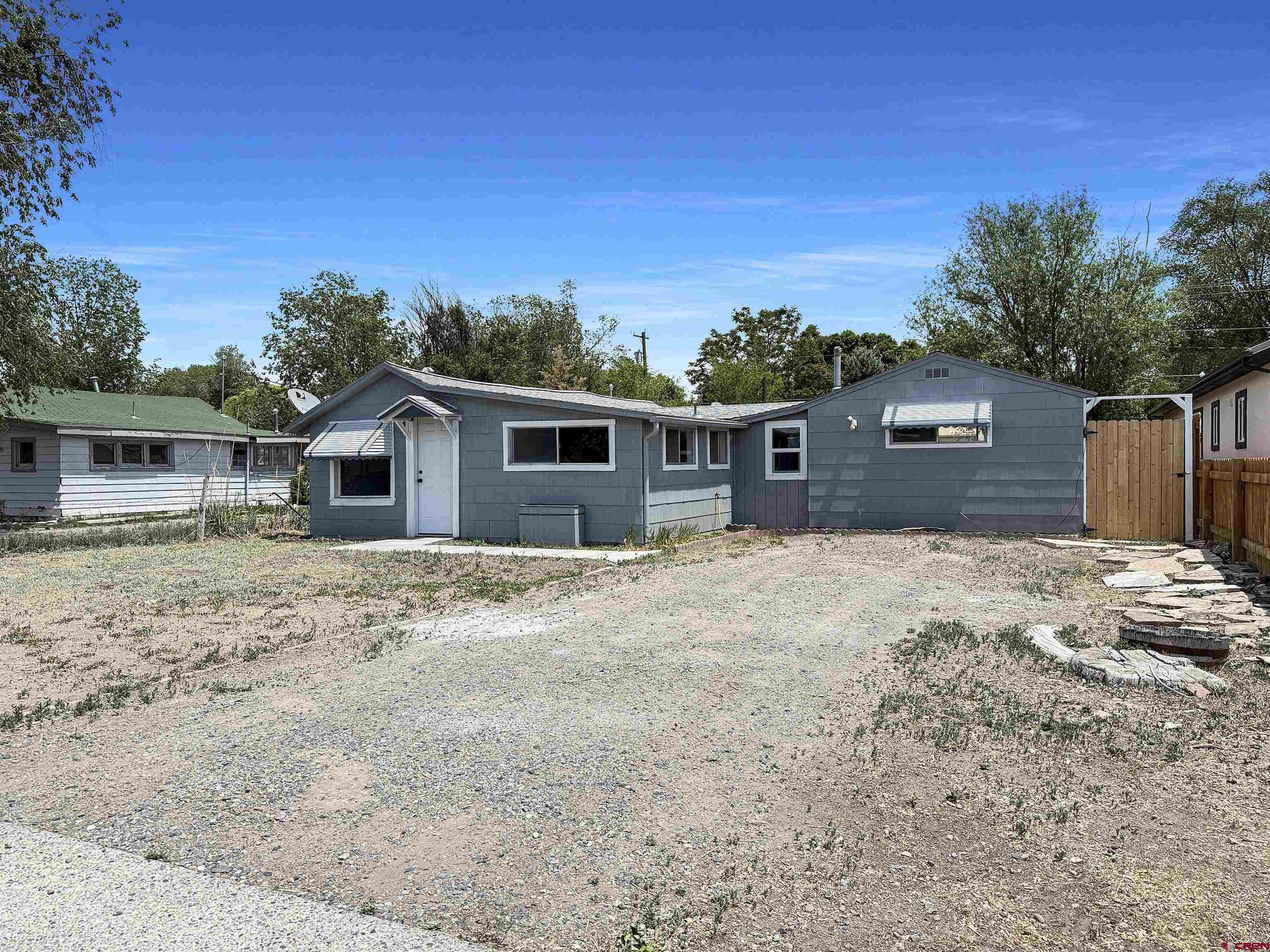 1246 Meeker Street Delta, CO 81416 - Photo 2 of 21 a front view of house with yard and trees in the background