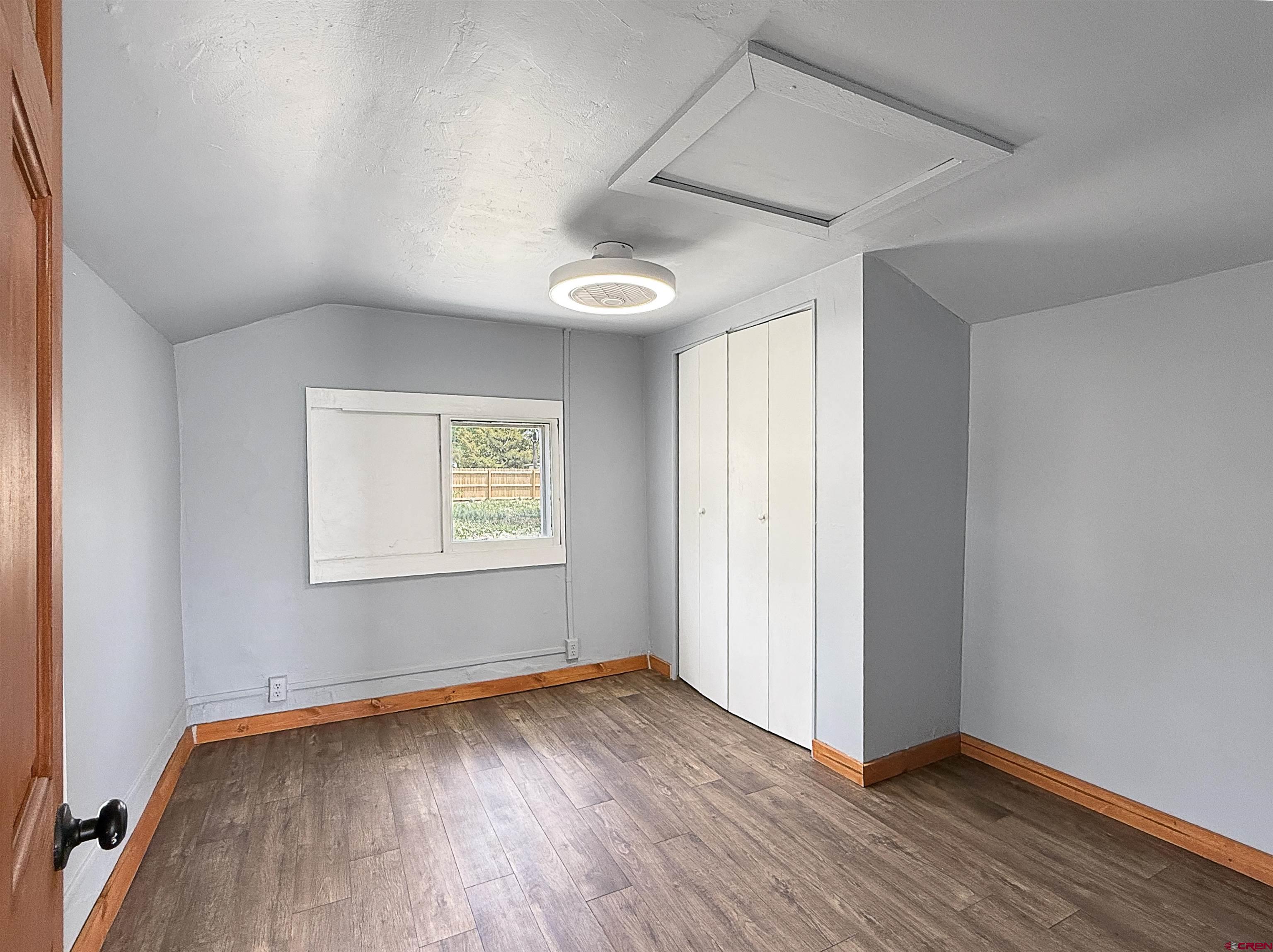 1246 Meeker Street Delta, CO 81416 - Photo 4 of 21 an empty room with wooden floor and windows
