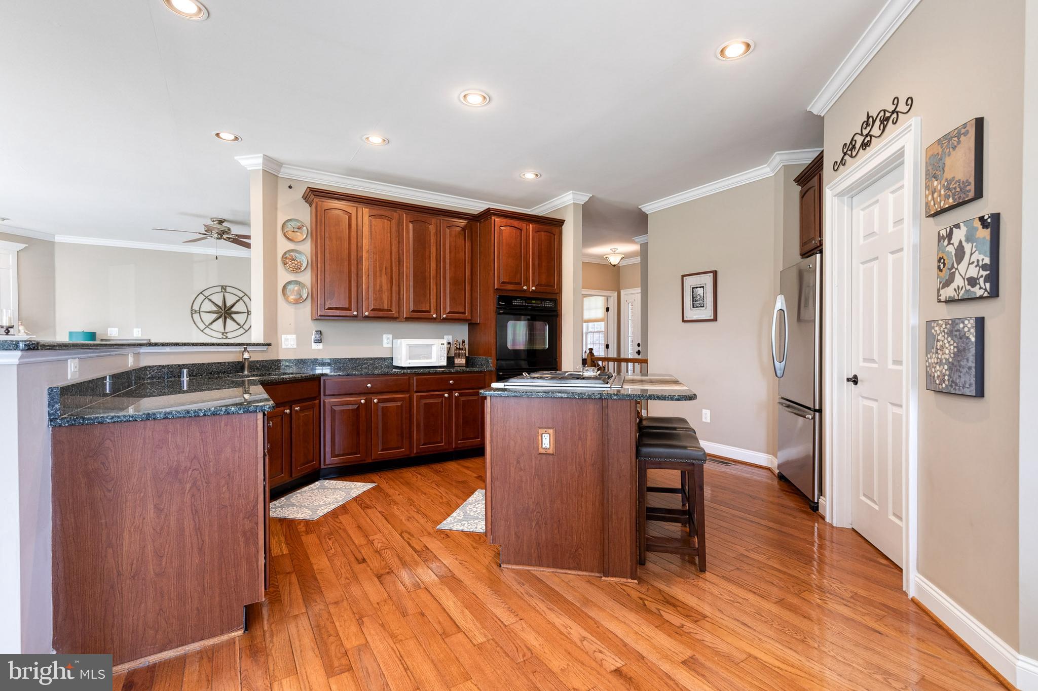 14942 Dover Road Reisterstown, MD 21136 - Photo 14 of 47 a kitchen with stainless steel appliances granite countertop a refrigerator a sink dishwasher a stove with wooden floor and cabinets