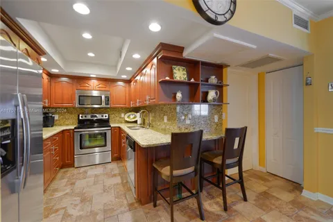 a kitchen with stainless steel appliances granite countertop a kitchen island a cabinets and a dining table