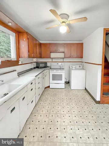 a kitchen with a sink a stove a refrigerator and cabinets