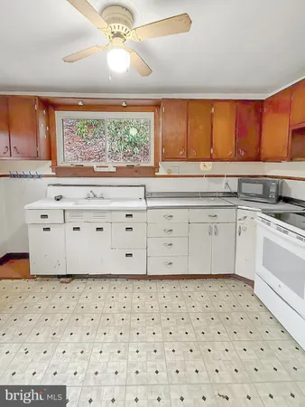 a kitchen with a sink a stove and white cabinets