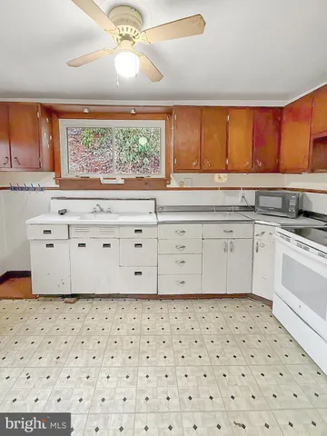 a kitchen with a sink a stove and white cabinets