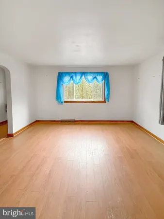 an empty room with wooden floor and window