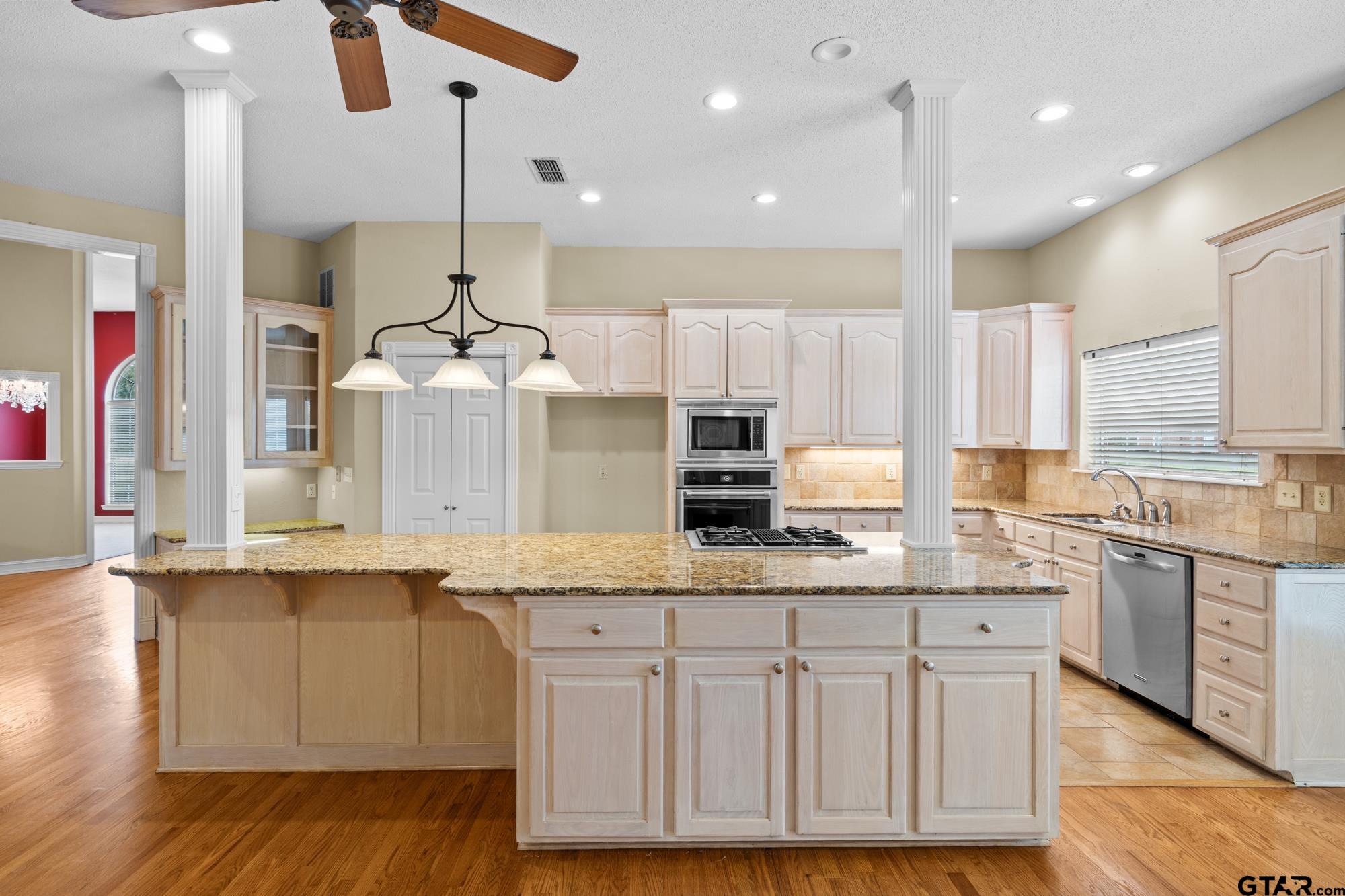 210 Lavender Lane Longview, TX 75605 - Photo 11 of 36 a kitchen with stainless steel appliances granite countertop a sink a stove and a wooden floors