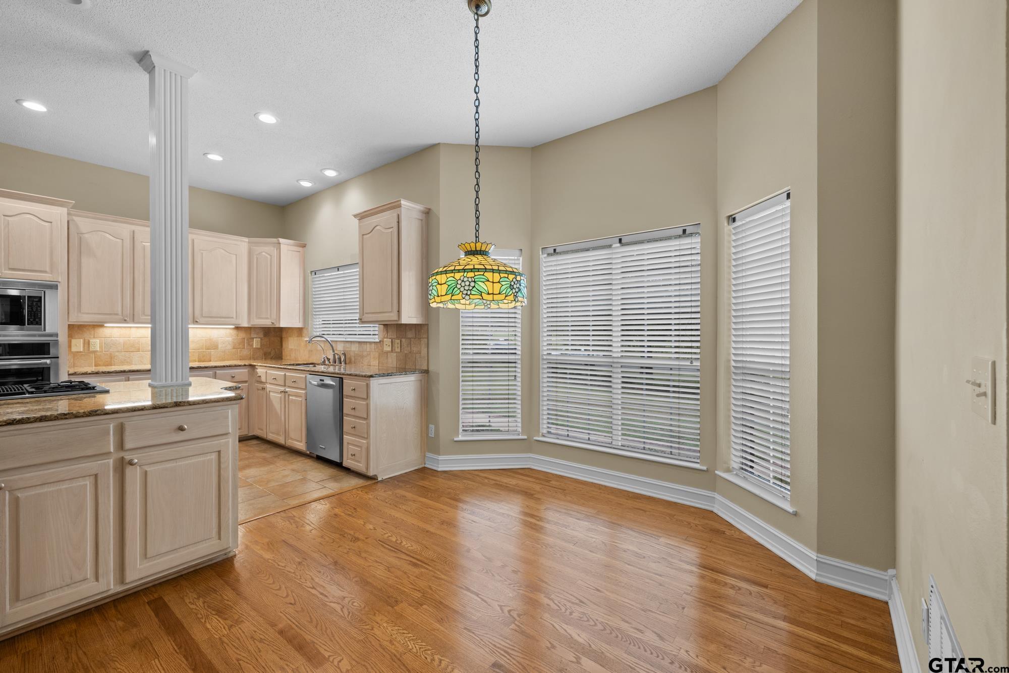 210 Lavender Lane Longview, TX 75605 - Photo 15 of 36 a kitchen with stainless steel appliances granite countertop a stove a sink and white cabinets with wooden floor