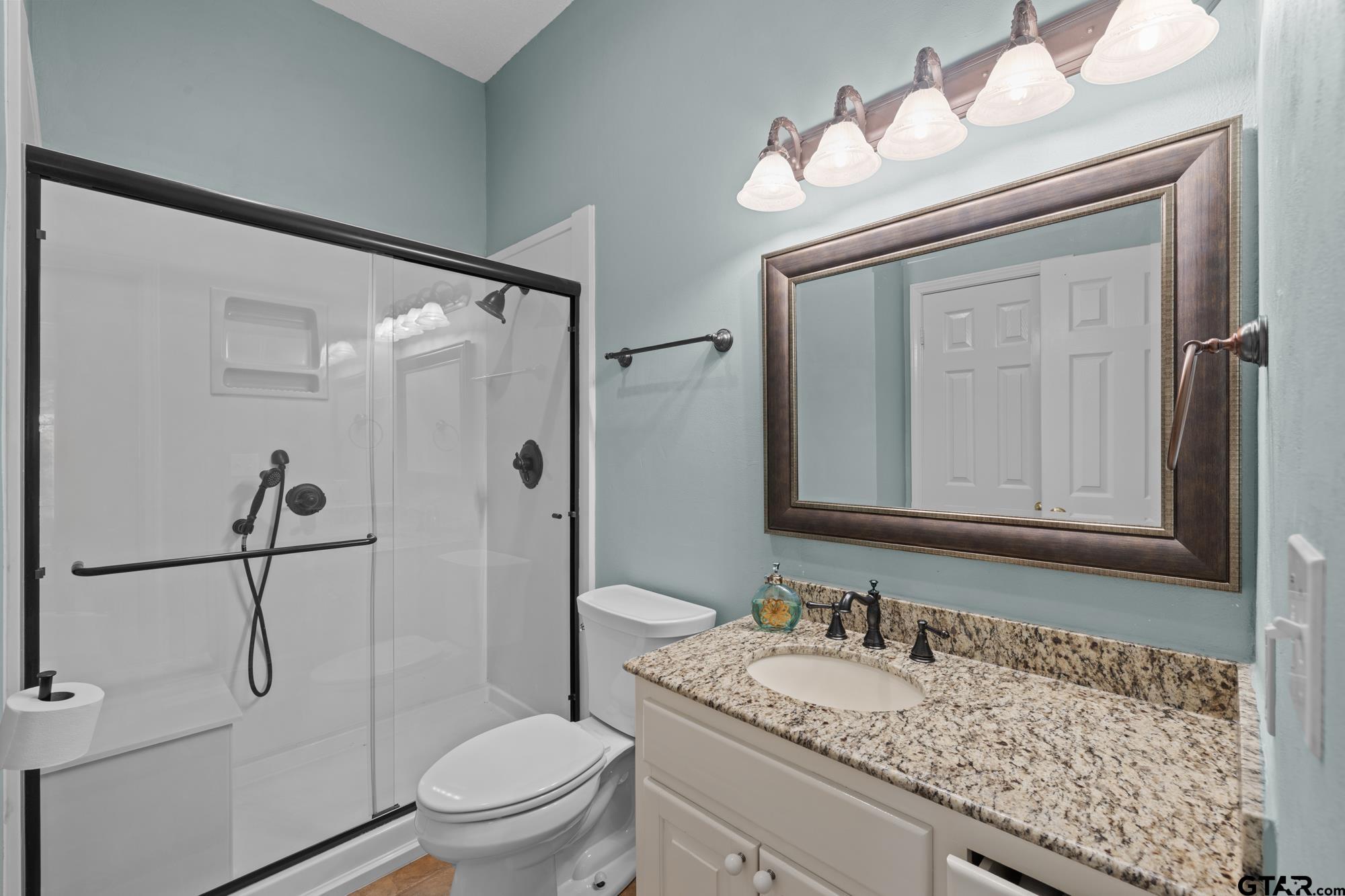 210 Lavender Lane Longview, TX 75605 - Photo 26 of 36 a bathroom with a granite countertop sink a toilet and a mirror
