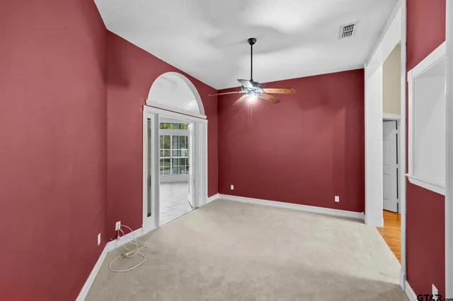 a view of a kitchen and an empty room with wooden floor