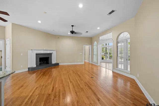 a kitchen with stainless steel appliances granite countertop a sink a stove and a wooden floors