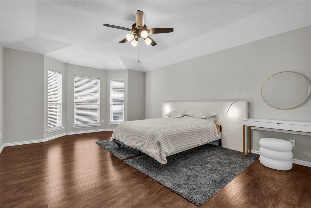 308 Glen Ridge Drive Murphy, TX 75094 - Photo 19 of 36 a spacious bedroom with a bed and a chandelier