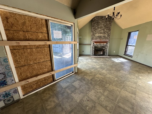 548 Spring River Drive Martindale, TX 78655 - Photo 9 of 17 Unfurnished living room with a stone fireplace, vaulted ceiling, and hanging lights