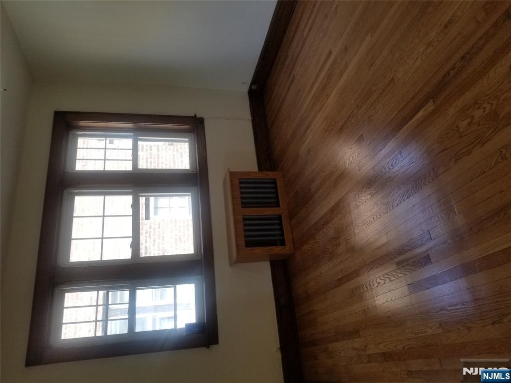 130-2 Rutherford Place, Unit 2L North Arlington, NJ 07031 - Photo 4 of 11 an empty room with wooden floor and windows