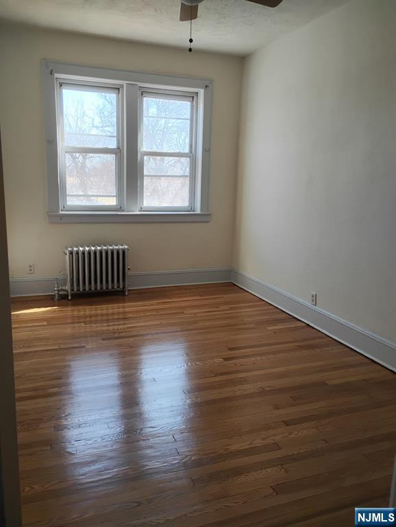 130-2 Rutherford Place, Unit 2L North Arlington, NJ 07031 - Photo 5 of 11 a view of an empty room with wooden floor and a window