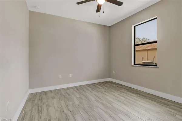 an empty room with a window and wooden floor