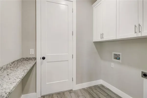 a view of a kitchen with white cabinets and wooden floor