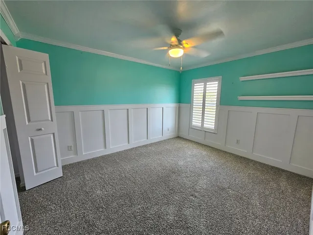 a view of an empty room with a window and kitchen view