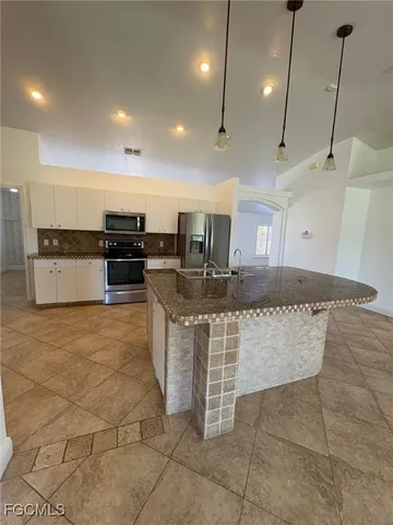 a kitchen with stainless steel appliances granite countertop a stove a sink a oven and a granite counter tops