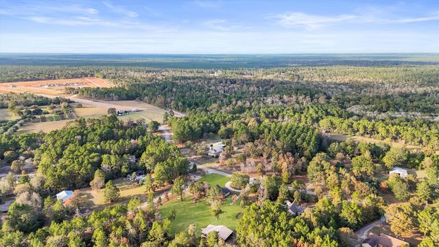 an aerial view of residential house with outdoor space and trees all around
