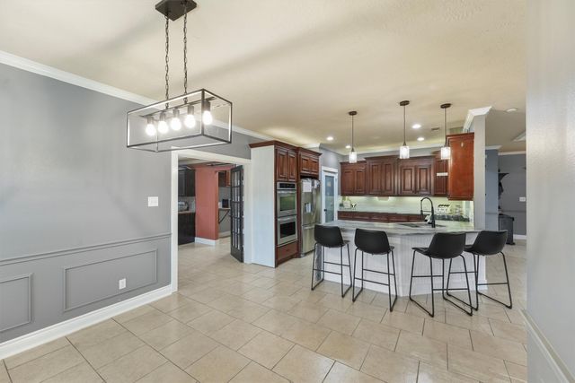 a view of a dining room and livingroom with furniture wooden floor a chandelier