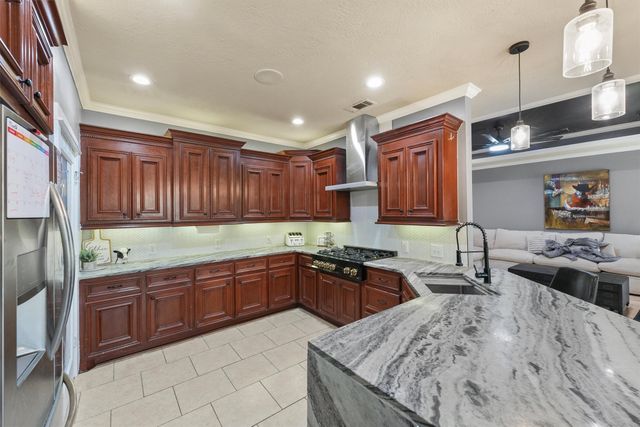 a kitchen with stainless steel appliances granite countertop sink stove and refrigerator