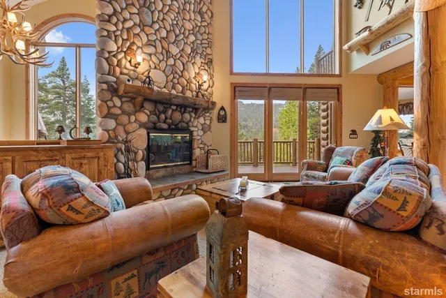 a living room with furniture a fireplace and a chandelier