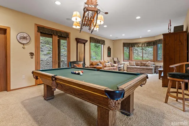 a room with pool table and windows