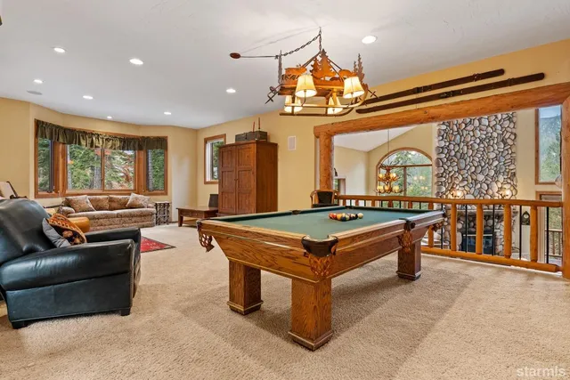 a kitchen with stainless steel appliances kitchen island granite countertop a table chairs and a refrigerator