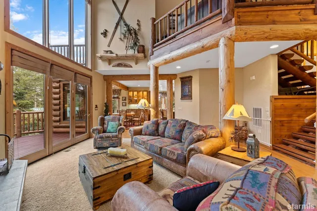 a living room with furniture a couch and large windows