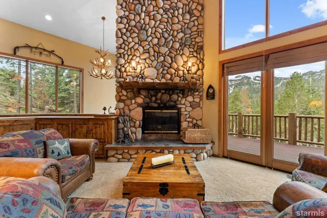 a living room with furniture a floor to ceiling window and a fireplace