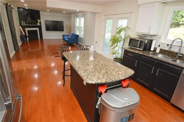 a kitchen with a sink a stove and chairs