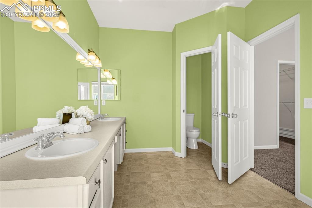 12383 Pine Valley Circle Peyton, CO 80831 - Photo 14 of 45 a bathroom with a sink vanity granite and a mirror