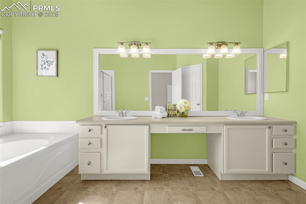 12383 Pine Valley Circle Peyton, CO 80831 - Photo 15 of 45 a bathroom with a double vanity sink and a bathtub