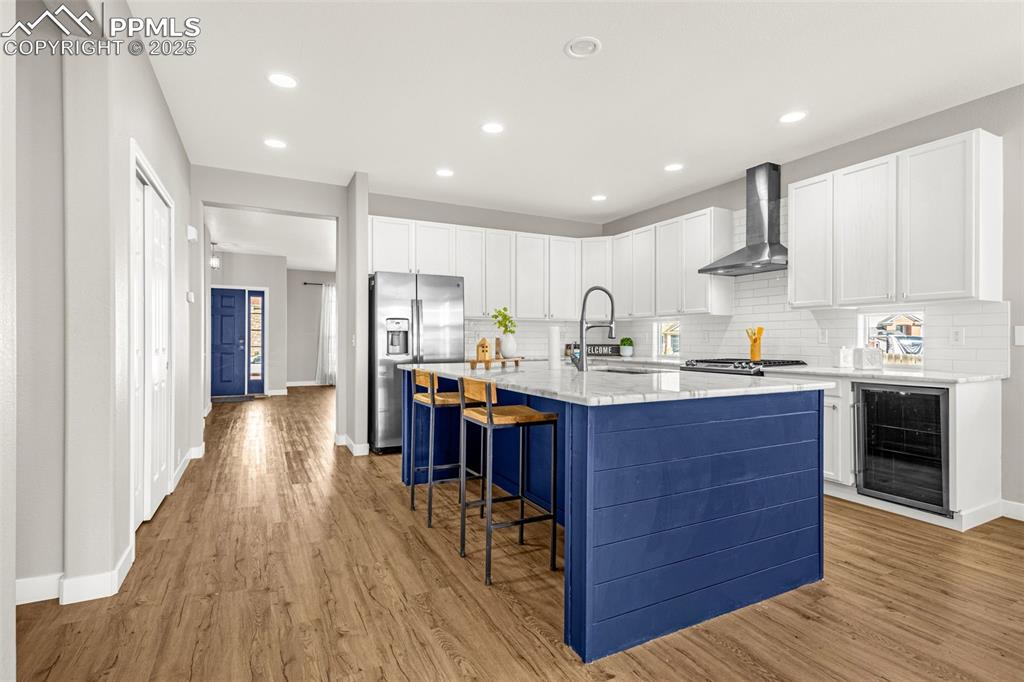 12383 Pine Valley Circle Peyton, CO 80831 - Photo 20 of 45 a kitchen with stainless steel appliances granite countertop wooden floors a stove a sink and a refrigerator